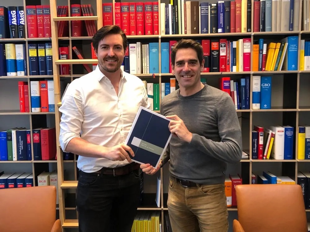 Christian Wenzel and his co-founder holding the founding documents in a law office