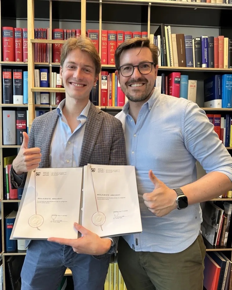 Christian Wenzel and his co-founder showing the certified founding documents