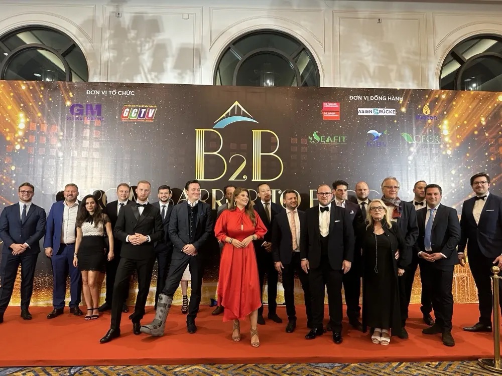 Group photo of the delegation in front of the B2B gala backdrop in Vietnam