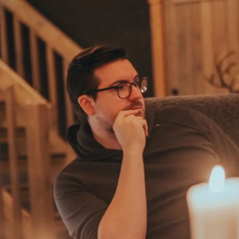 Christian Wenzel sitting thoughtfully behind candles