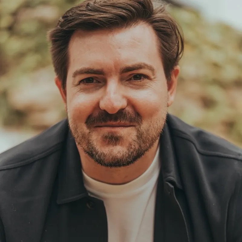 Close-up of Christian Wenzel in a dark jacket and white T-shirt