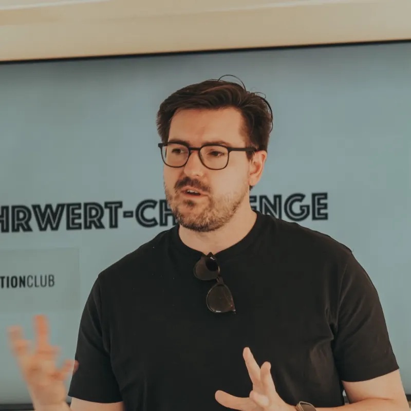 Christian Wenzel spricht vor einem Bildschirm in der Workation-Runde